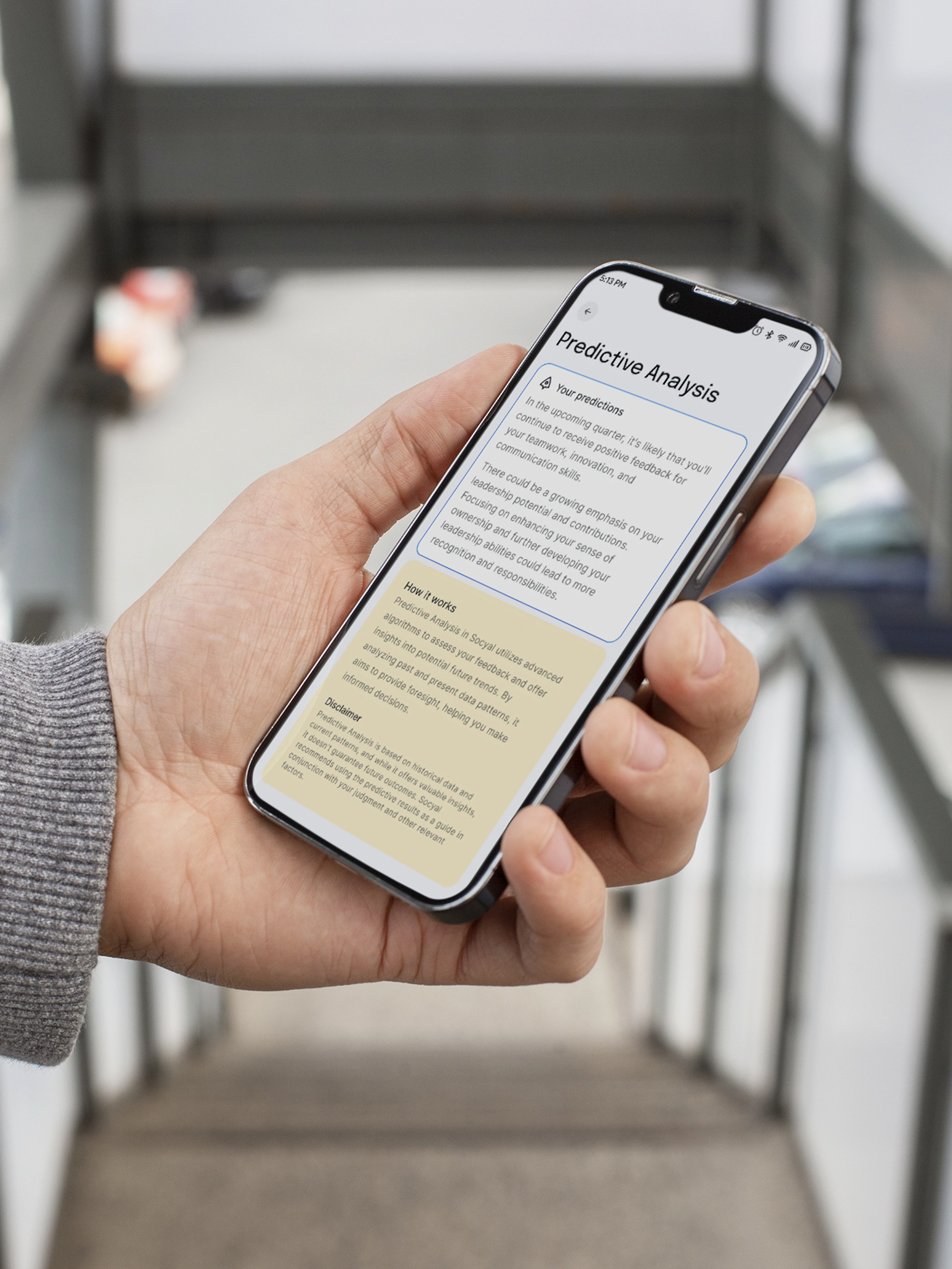 Socyal predictive analysis feature screen on phone held in hand on staircase